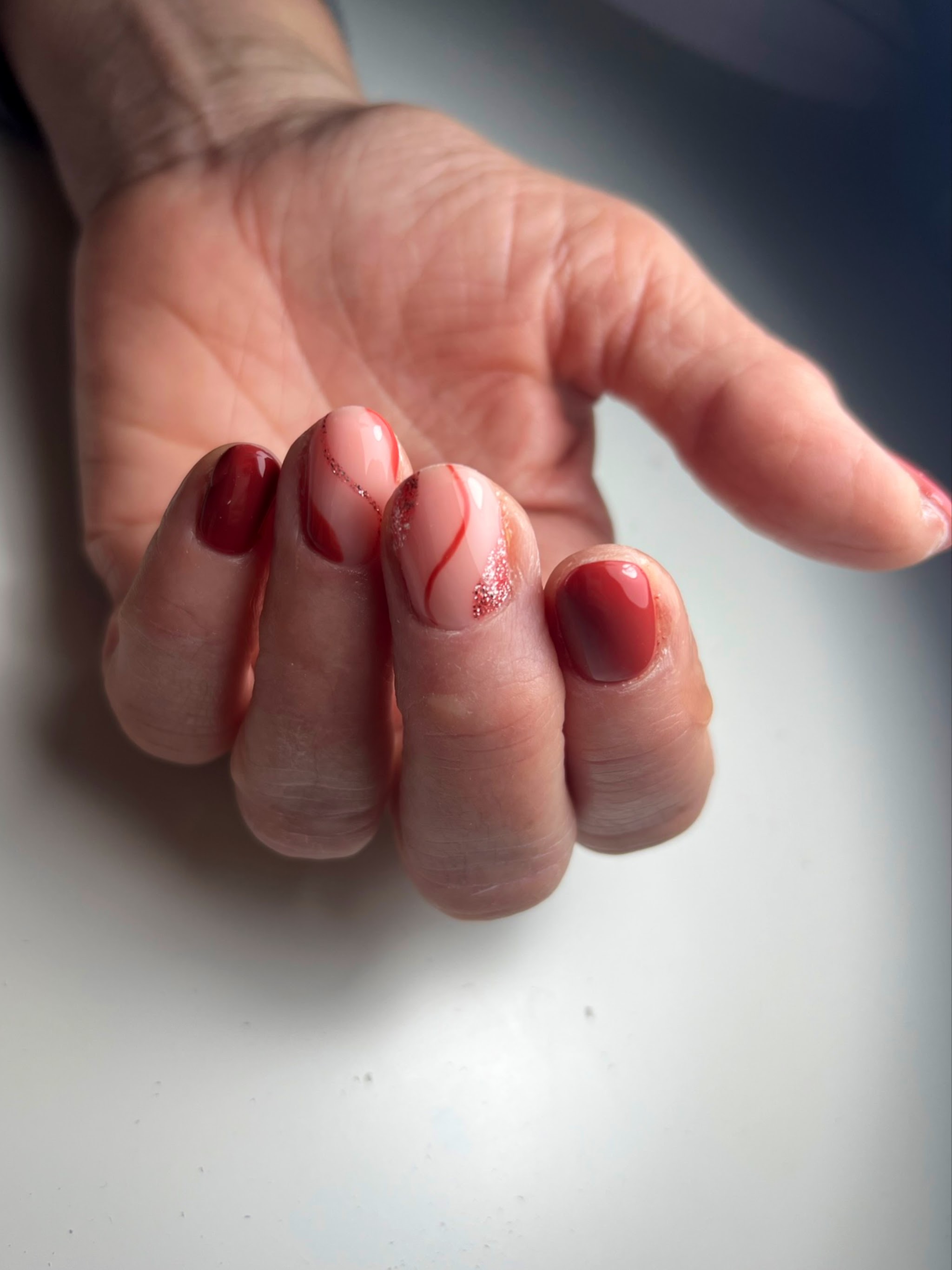 Rode en koperkleurige nagels met fijne nailart