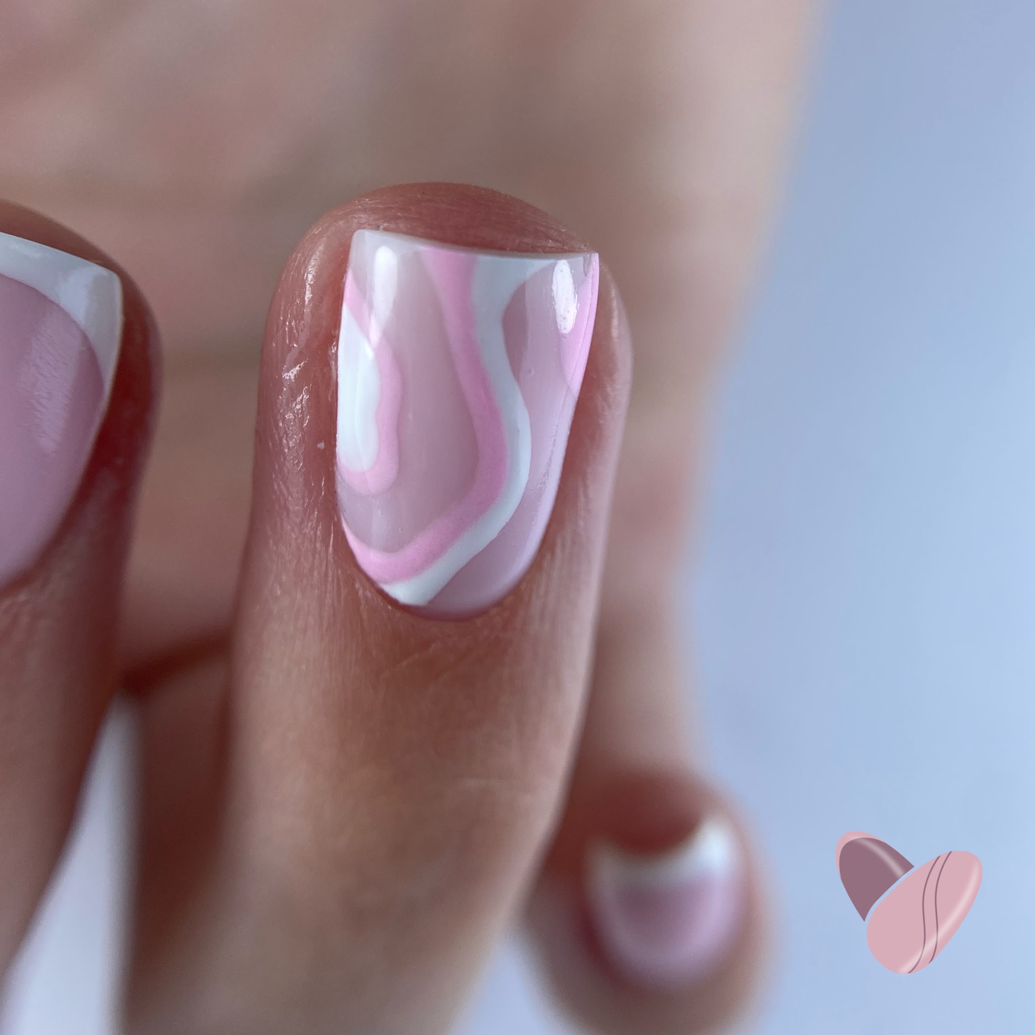 Close-up van een nagel met roze en witte swirl nailart