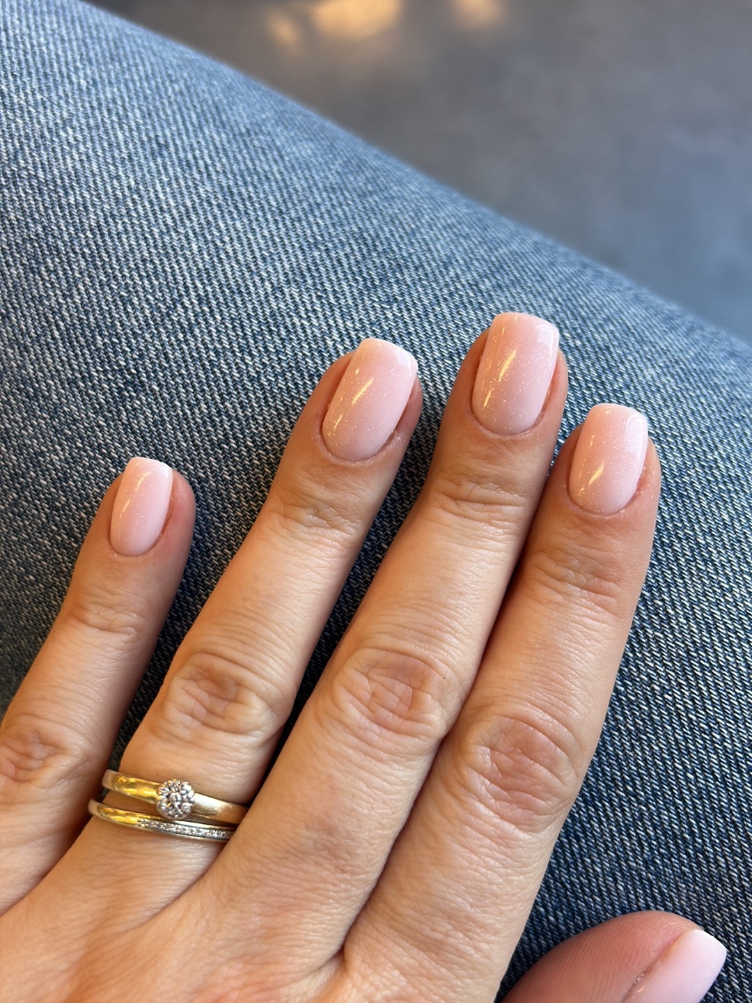 Natuurlijke lichtroze nagels met gouden ringen